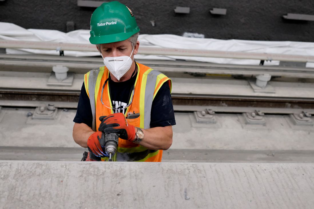 A construction worker drills into the platform